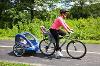 Woman cycling with child in trailer