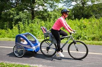 Woman cycling with child in trailer